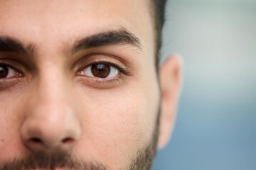 Obraz premium young beautiful man with brown eyes looks at the camera.