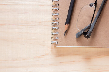 notebook and pencil on wooden table