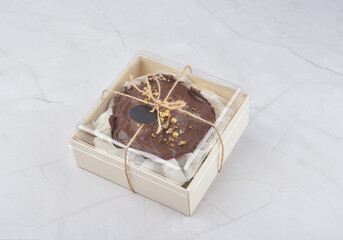 premium freshly baked dark cocoa chocolate brownie gold flower and earl grey peanut round birthday cake with walnut in wood bento box on white marble halal food sweet dessert menu for pastry cafe shop