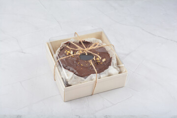 premium freshly baked dark cocoa chocolate brownie gold flower and earl grey peanut round birthday cake with walnut in wood bento box on white marble halal food sweet dessert menu for pastry cafe shop