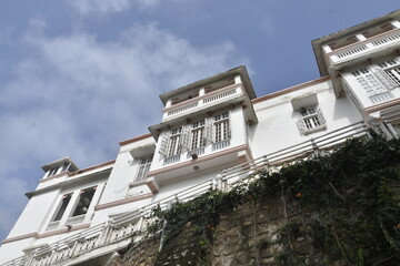 Charming White-Facade Building With Balconies and Greenery Under a Clear Sky at  Merwara estate Ajmer
