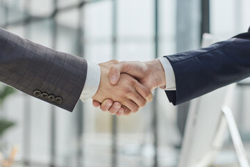 Building a strong business network. two businessmen shaking hands in a modern office.