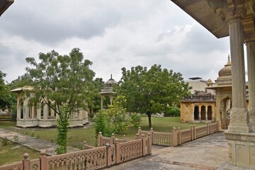 Obraz premium Majestic Royal Cenotaphs Amidst Verdant Greenery Under Cloudy Skies at Maharani Ki Chhatri ,Jaipur, Rajasthan, India