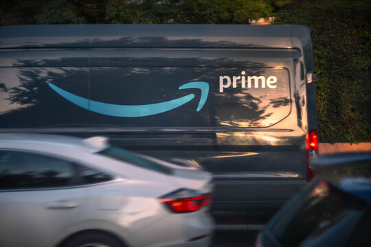 LOS ANGELES, CA - March 13, 2024: Amazon Prime delivery van delivering packages on a busy residential street in Hollywood at sunset.