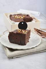 premium freshly baked dark cocoa chocolate brownie gold flower and earl grey peanut round birthday cake with walnut in wood bento box on white marble halal food sweet dessert menu for pastry cafe shop