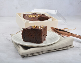 premium freshly baked dark cocoa chocolate brownie gold flower and earl grey peanut round birthday cake with walnut in wood bento box on white marble halal food sweet dessert menu for pastry cafe shop