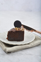 premium freshly baked dark cocoa chocolate brownie gold flower and earl grey peanut round birthday cake with walnut in wood bento box on white marble halal food sweet dessert menu for pastry cafe shop