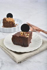 premium freshly baked dark cocoa chocolate brownie gold flower and earl grey peanut round birthday cake with walnut in wood bento box on white marble halal food sweet dessert menu for pastry cafe shop
