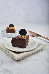premium freshly baked dark cocoa chocolate brownie gold flower and earl grey peanut round birthday cake with walnut in wood bento box on white marble halal food sweet dessert menu for pastry cafe shop