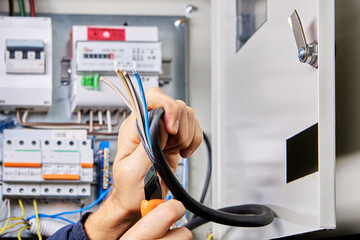 Removing outer sheath of PVC insulation from power cable for connection to switchboard.