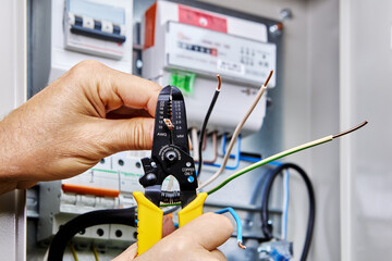 Tool for stripping wires is used when installing an outdoor electrical panel with an electricity...