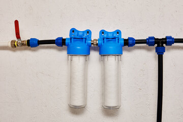 Dual Stage Water Filtration System Installed on a White Wal