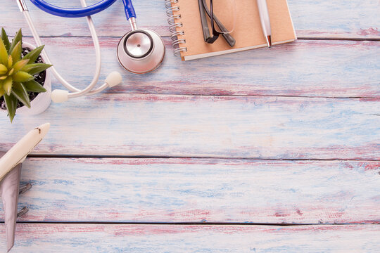 Flat lay photo with blank notebook,glasses,airplane model,flower, pen and blue stethoscope