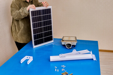Bracket for mounting solar panel and LED light of street lighting, user prepares for installation.