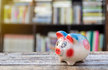 Piggy bank on wooden table over blurred background