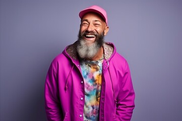 Portrait of a stylish hipster man laughing over purple background.