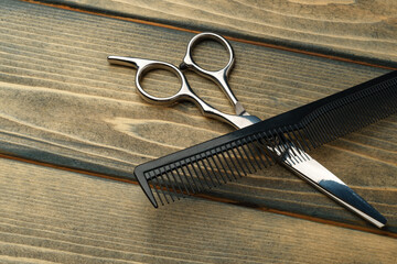 Hairdressing professional scissors on wooden background close up