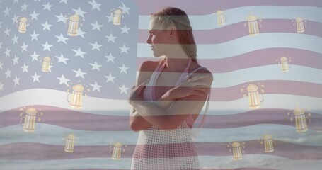 Animation of american flag and beer mugs over happy caucasian woman smiling on sunny beach - Powered by Adobe