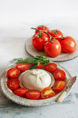 Mild burrata cheese. Burrata cheese served with cherry tomatoes and olive oil.