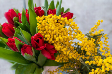 tulips with mimosa. Spring bouquet with mimosa flowers and red tulips - spring concept, spring natural background.