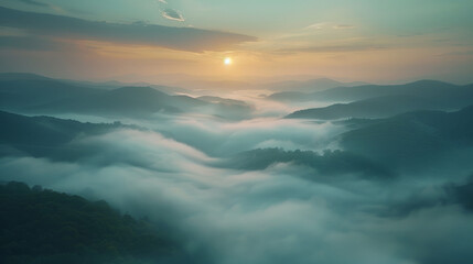 A serene landscape captures rolling hills enveloped in a blanket of soft mist under a tranquil dawn sky. The sun, breaking through the haze, offers a gentle glow