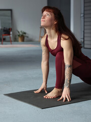 Power yoga for strong arms. Beautiful young woman doing stretching exercises.