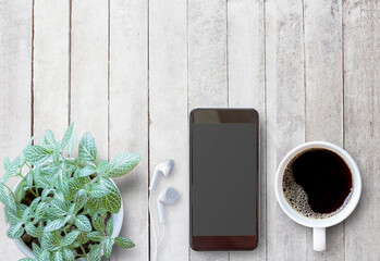  Smart phone and cup of coffee on old wooden background with copy space.