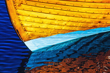 Keel of a wooden boat with water reflections
