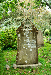 Alter verwitterter Grabstein hinter einer alten Kirche in Cornwall 