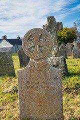 Alter Grabstein mit Kreuz neben einer alten Kirche in Cornwall 