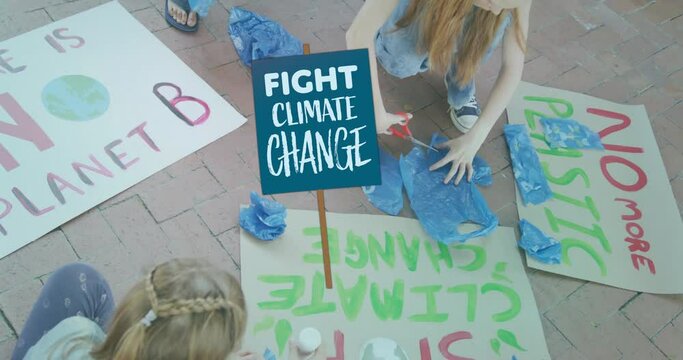 Animation of fight climate change placard over diverse children making ecology protest banners