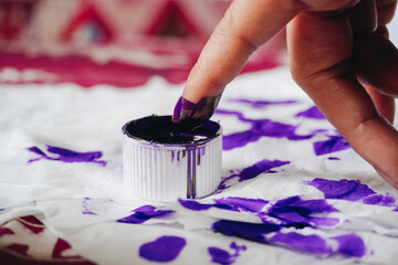 Close up portrait of little finger dipping into purple ink after voting for Indonesia President and...
