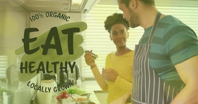 Animation of eat healthy text over diverse couple preparing healthy meal in kitchen