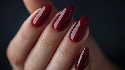A woman's hand with a beautiful burgundy manicure.