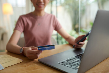 Smiling woman paying for online services with credit card
