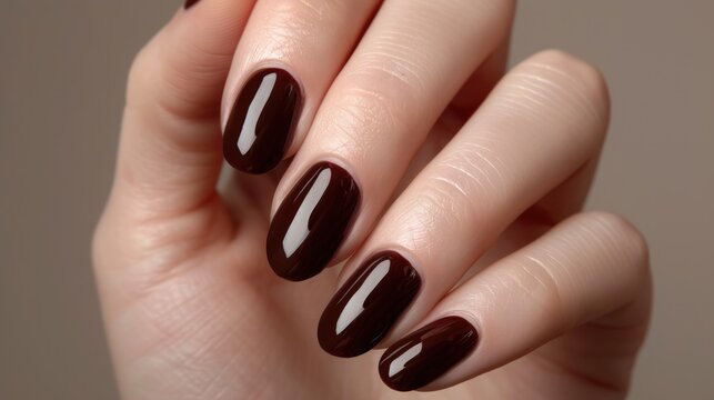 Burgundy brown manicure on a woman's hand.