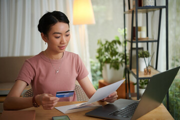 Woman reading letter from bank that came with credit card