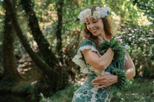 Woman dancing Hawaiian dance outdoors in the natural rainforest. Concept of Polynesian cultural diversity. Sensation of freedom and movement.
