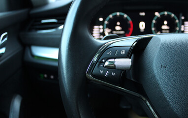 Defocused backlight of LED dashboard behind car steering wheel with heating and voice control...