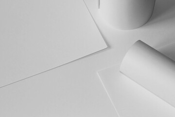 Design Studio Mockup. Blank Paper Rolls, Paper Sheets on Office Desk. Graphic Design Concept.