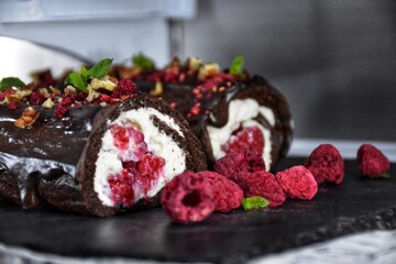 Sweet chocolate roll with whipped cream and raspberries