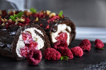 Sweet chocolate roll with whipped cream and raspberries