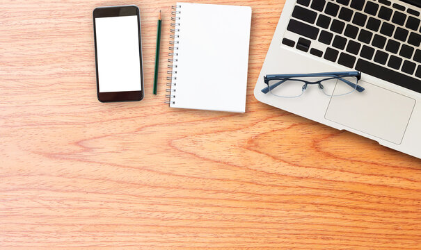 laptop comuter with smart phone on wooden desk
