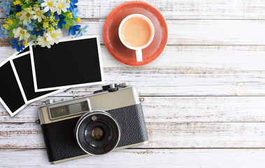 Vintage film camera and two blank photo frames on wooden table