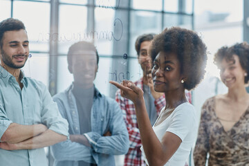 Obraz premium a team of young designers sticking notes on glass in a modern office