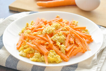 Carrot and egg stir fry on a white plate. Healthy and dietary food concept. 