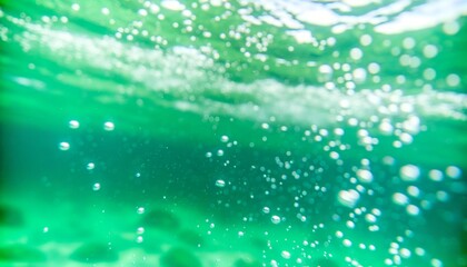 Bubbles and bokeh underwater in clear green ocean