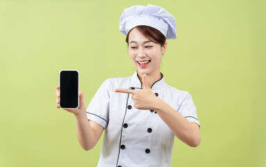 Photo of young Asian female chef on background