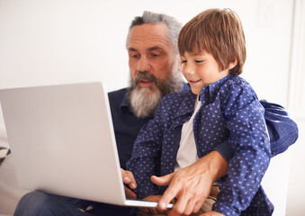 Grandfather, laptop and boy child for elearning, playing and bonding in living room. Happy family, relax and internet for games or learning online, childhood or development or streaming on technology