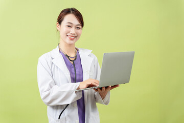 Photo of young Asian femle doctor on green background